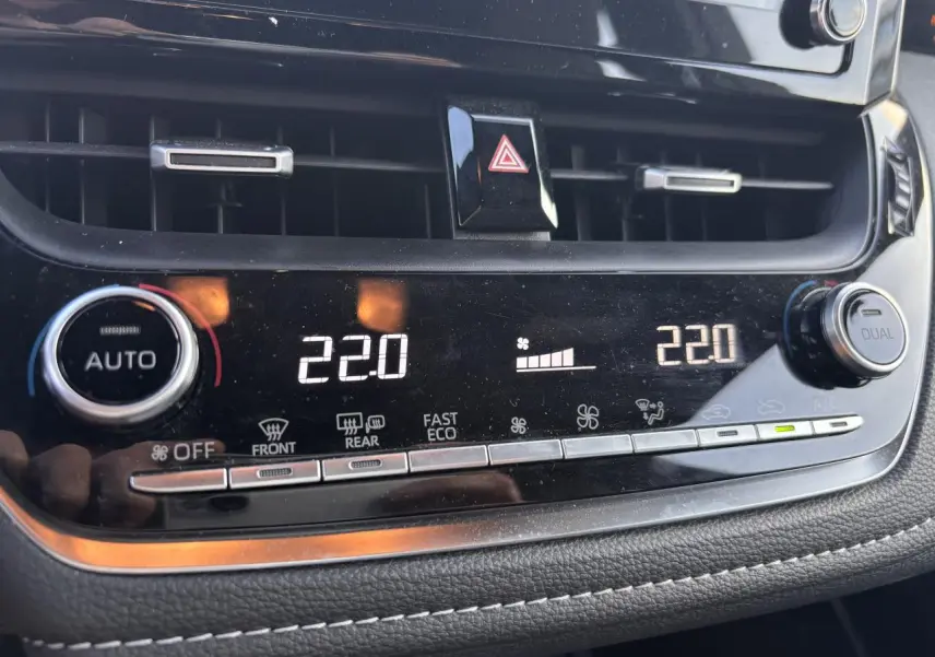 Détail du tableau de bord de la Toyota Corolla hybride 2020 montrant la climatisation automatique réglée à 22°C.