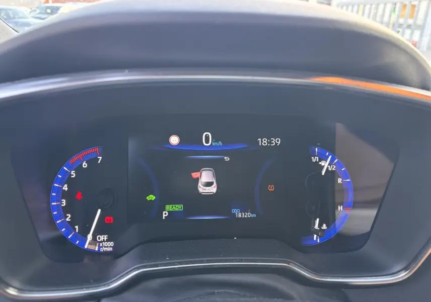 Tableau de bord numérique de la Toyota Corolla hybride 2020, affichant la vitesse à 0 km/h et divers indicateurs lumineux.