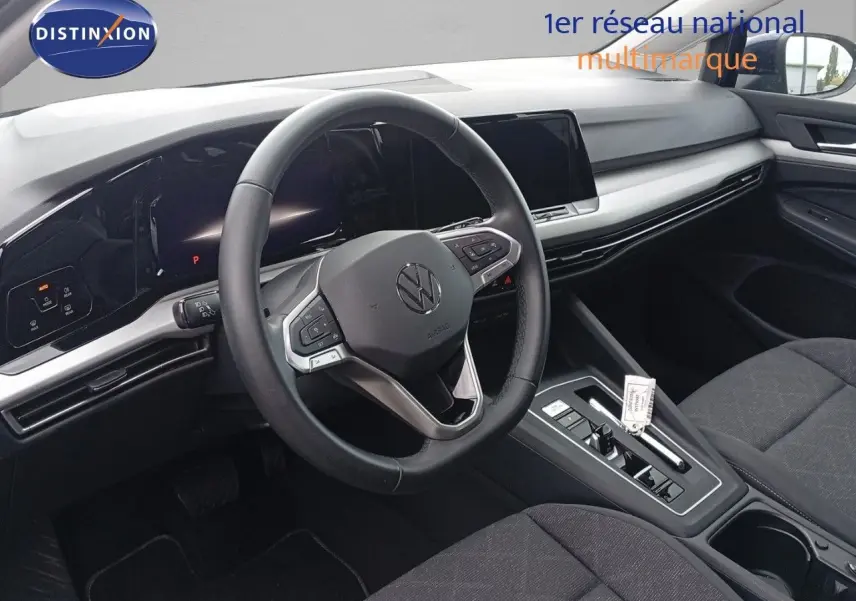 Intérieur de la Volkswagen Golf VIII 2023 vu côté conducteur, volant multifonction et tableau de bord numérique.
