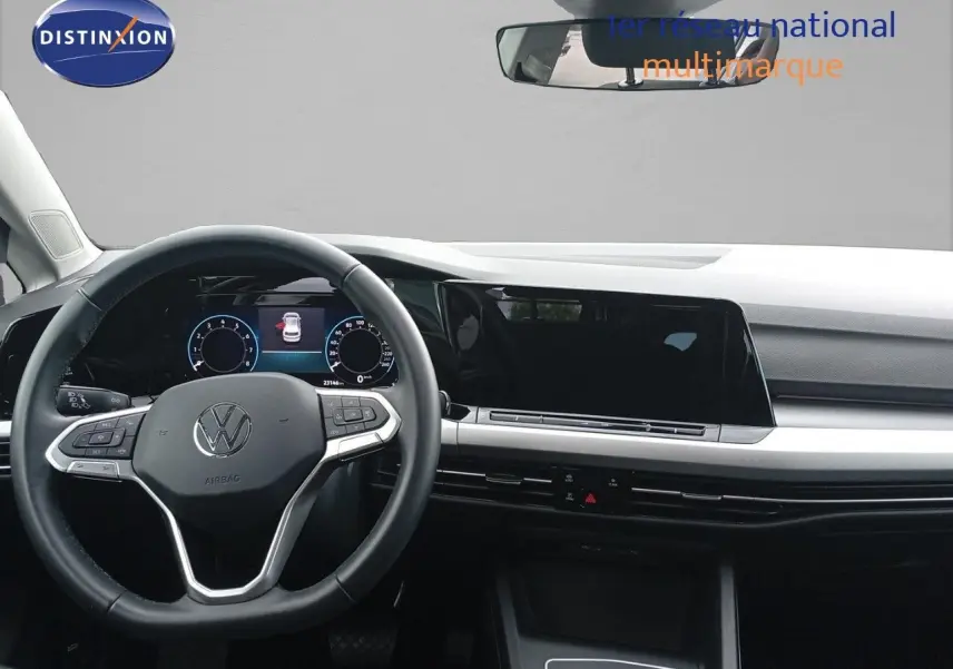 Vue intérieure frontale du tableau de bord et volant noir de la Volkswagen Golf VIII bleu Atlantique métal de 2023.