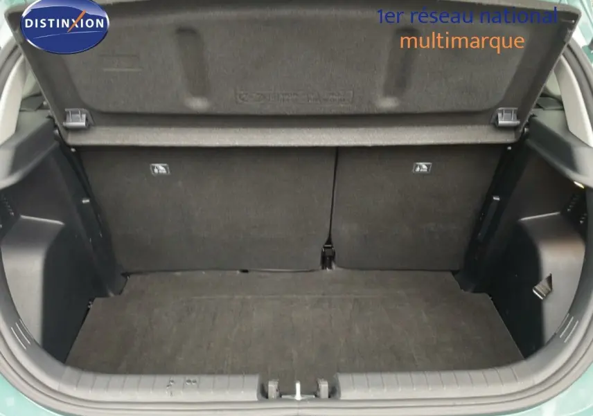 Coffre ouvert vu de l'arrière d'une Hyundai i20 2025 vert mangrove metal, montrant l'espace de chargement vide.