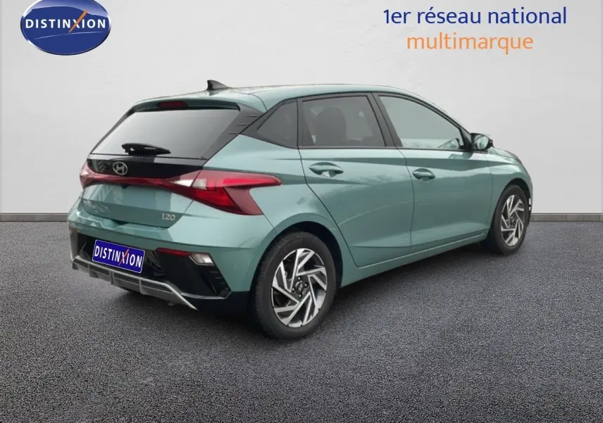 Vue 3/4 arrière droite d'une Hyundai i20 2025 vert mangrove métal avec feux arrière LED et jantes alliage.
