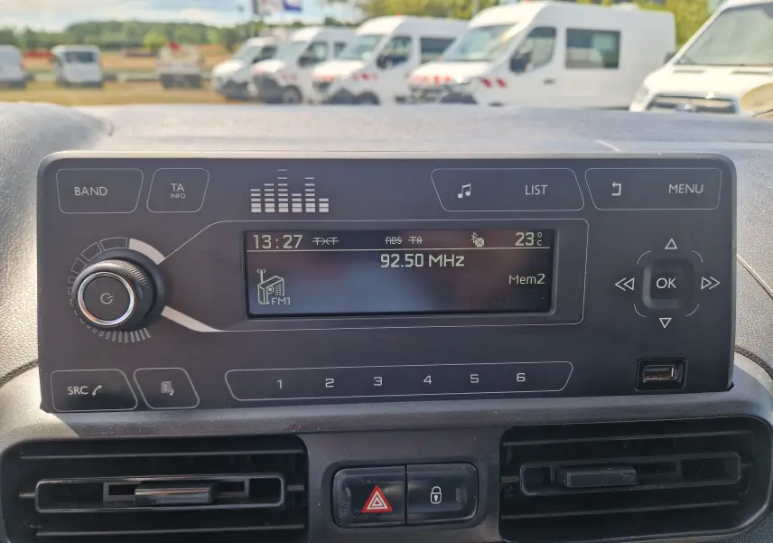 Vue rapprochée du tableau de bord du Citroën Berlingo blanc 2020, affichant la radio FM et les commandes centrales.