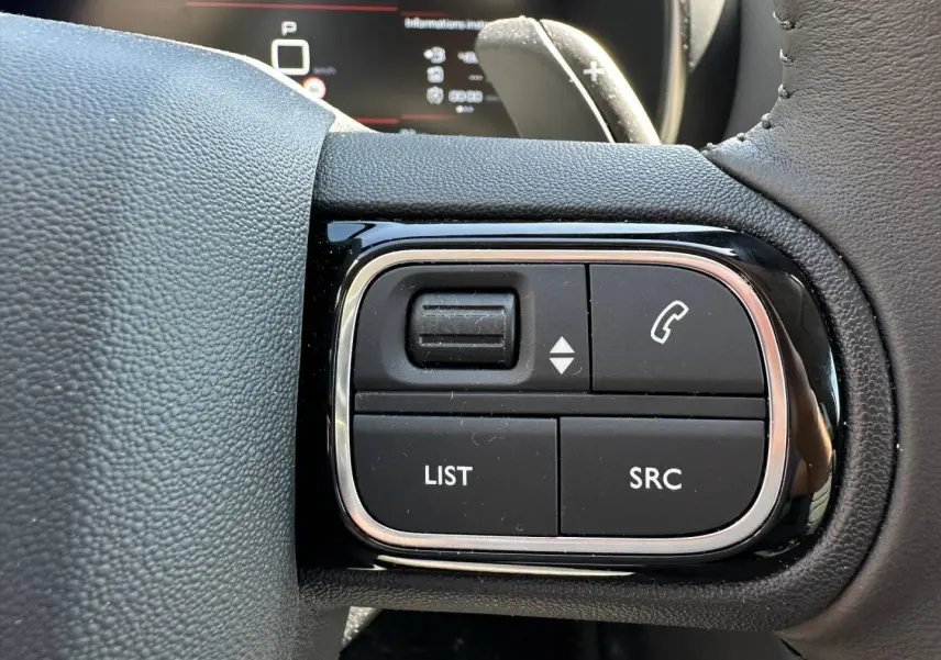 Gros plan sur les commandes noires du volant cuir du Citroën C5 Aircross 2025, finition Gris Platinium.