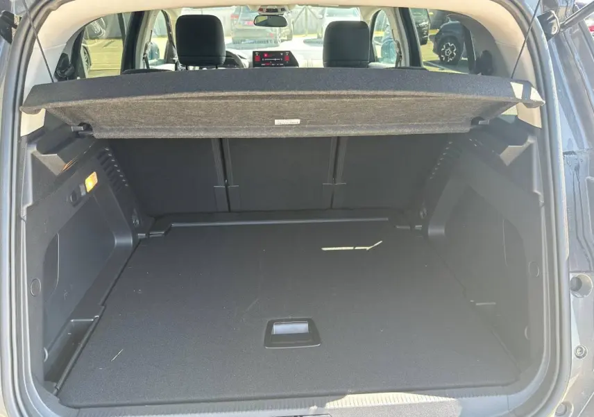 Coffre ouvert vu de l’arrière d’un Citroën C5 Aircross gris Platinium avec cache-bagages et sièges arrière visibles.