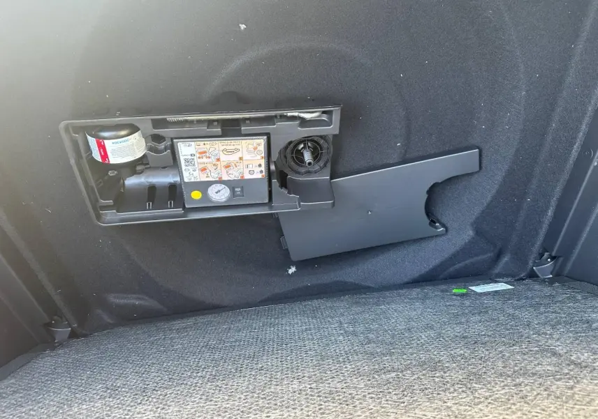 Détail du coffre du Citroën C5 Aircross gris Platinium montrant le compresseur et kit de réparation pneus intégré.