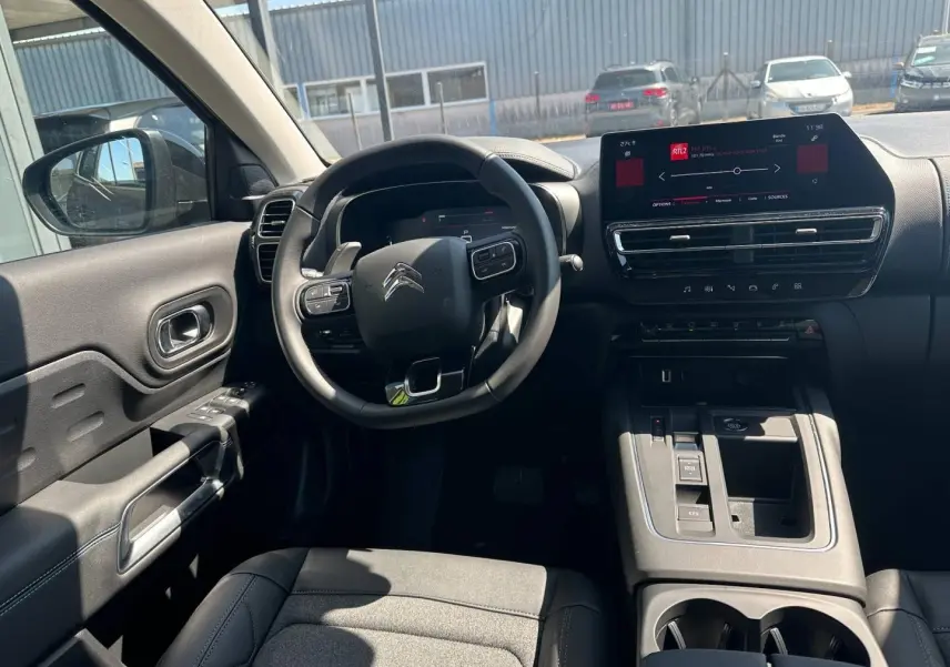 Vue intérieure avant du Citroën C5 Aircross gris Platinium, avec volant multifonction et écran tactile central.