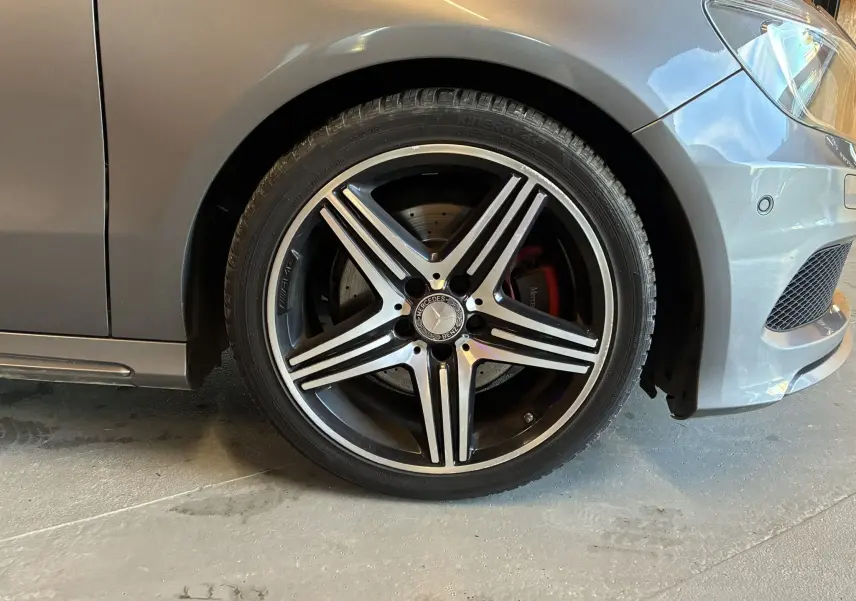 Gros plan sur la roue avant droite gris métallisé d'une Mercedes Classe A 250 AMG Sport avec jante alliage cinq branches.