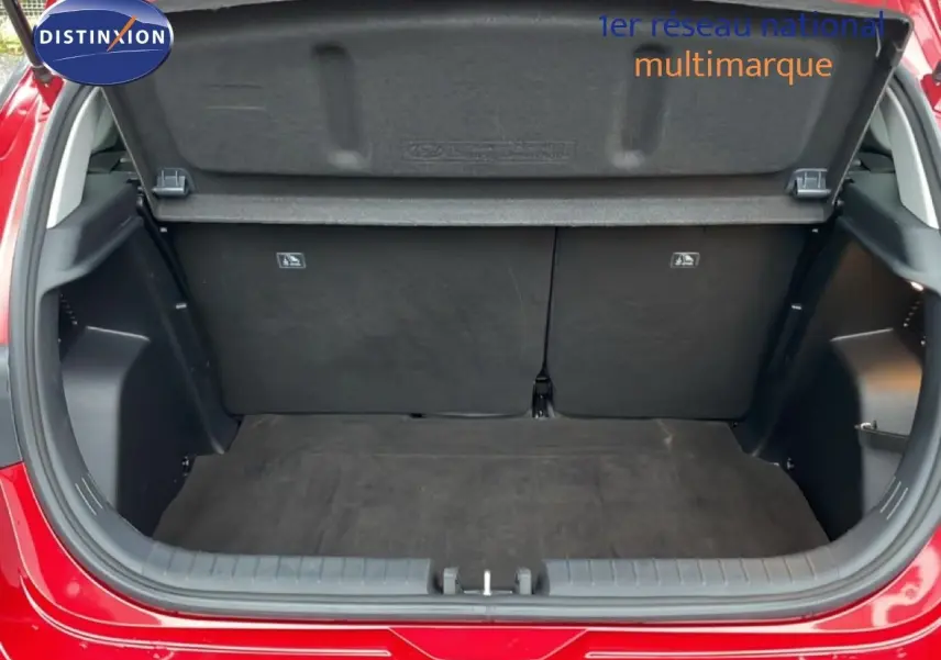 Coffre ouvert vu de l'arrière d'une Hyundai i20 rouge Dragon Metal, montrant l'espace de chargement vide.