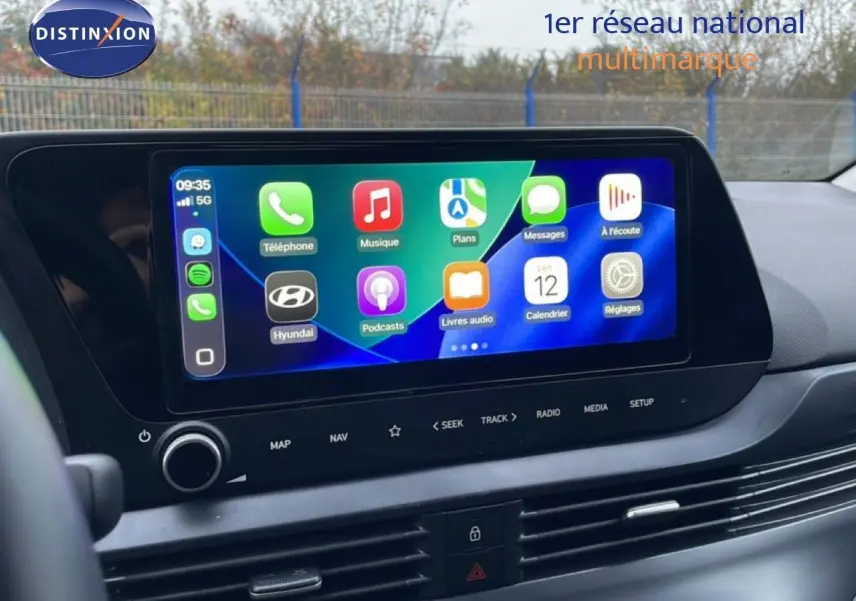 Écran tactile central allumé avec interface Apple CarPlay dans l'habitacle d'une Hyundai i20 rouge Dragon Metal.