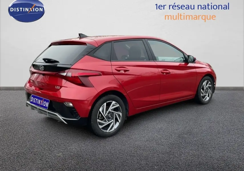 Vue 3/4 arrière droite d'une Hyundai i20 rouge Dragon Metal avec jantes alliage et vitres teintées.