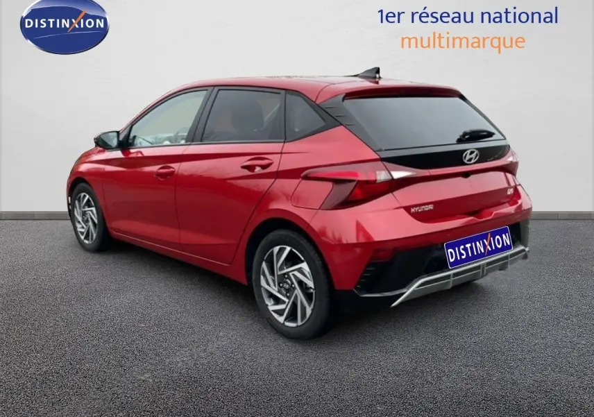 Vue 3/4 arrière droite d'une Hyundai i20 2025 rouge Dragon Metal avec feux LED et jantes alliage distinctives.