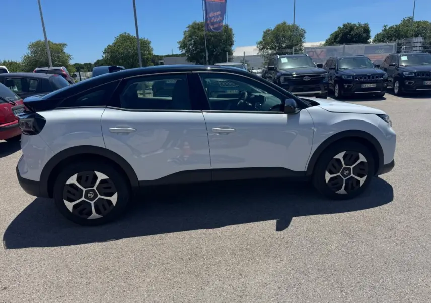 Citroën C4 hybride blanc vue de profil côté gauche, avec toit noir et jantes alliage 18 pouces.