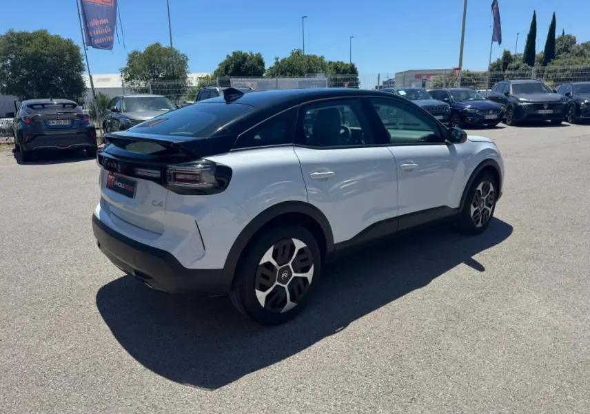 Citroën C4 hybride blanc vue 3/4 arrière droit avec toit noir et jantes alliage 18 pouces.