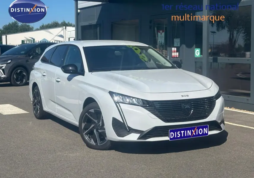 Peugeot 308 SW blanc Okénite vue 3/4 avant droit, avec jantes alliage et calandre noire distinctive.