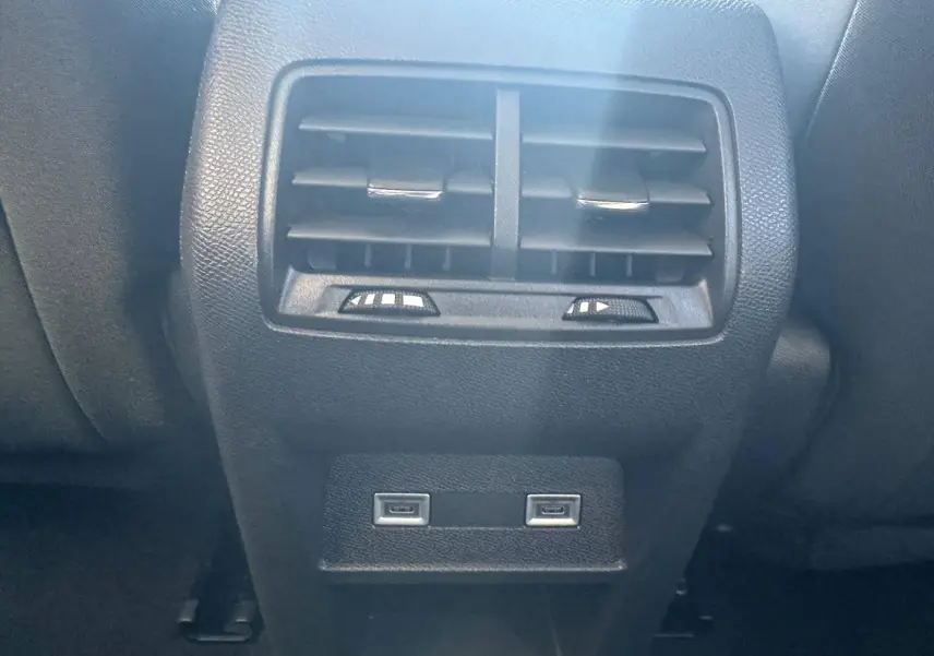 Vue rapprochée de la console arrière noire avec bouches d'aération et deux ports USB du Peugeot 308 SW blanc Okénite.