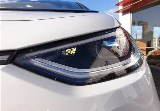 Gros plan sur le phare avant droit blanc glacier du Volkswagen ID.3 204 ch 1st Max électrique de 2020, avec reflet urbain.