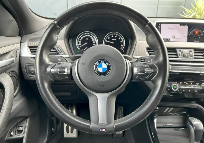 Vue frontale du volant cuir M et tableau de bord avec écran GPS du BMW X2 F39 bleu Misano hybride 2021