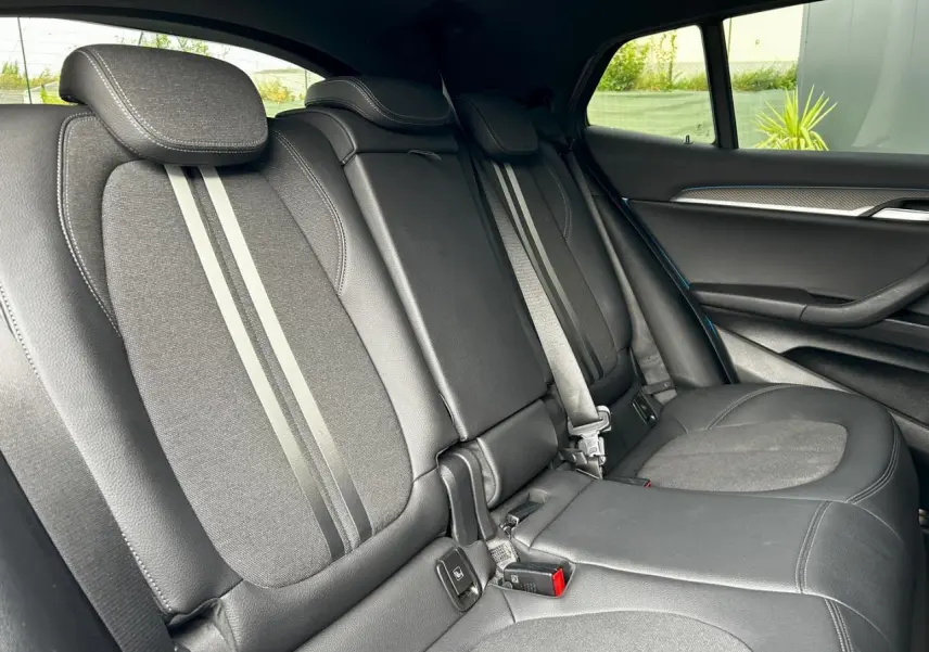 Vue latérale intérieure des sièges arrière en cuir noir et tissu avec surpiqûres contrastées du BMW X2 F39 2021.