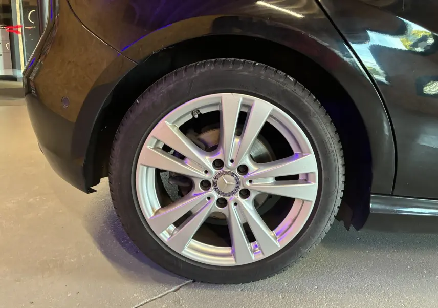 Gros plan sur la roue arrière droite argentée d'une Mercedes Classe A 180 CDI noire, mettant en valeur la jante 17 pouces.