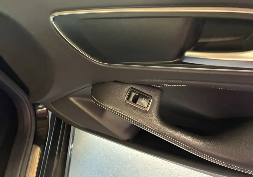 Gros plan sur la commande de lève-vitre côté conducteur de la porte noire intérieure d'une Mercedes Classe A 180 CDI Sensation 2018.