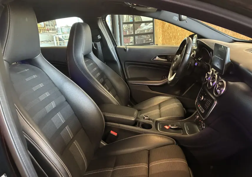 Intérieur noir de la Mercedes Classe A 180 CDI Sensation 2018, vue côté conducteur avec sièges en cuir et tableau de bord moderne.
