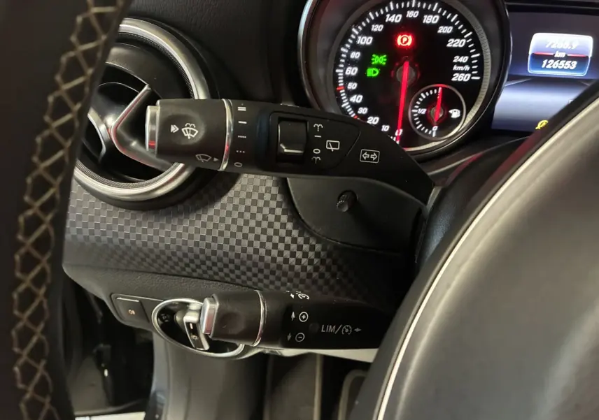 Gros plan sur la commande de clignotants et le tableau de bord noir d'une Mercedes Classe A 180 CDI Sensation 2018.