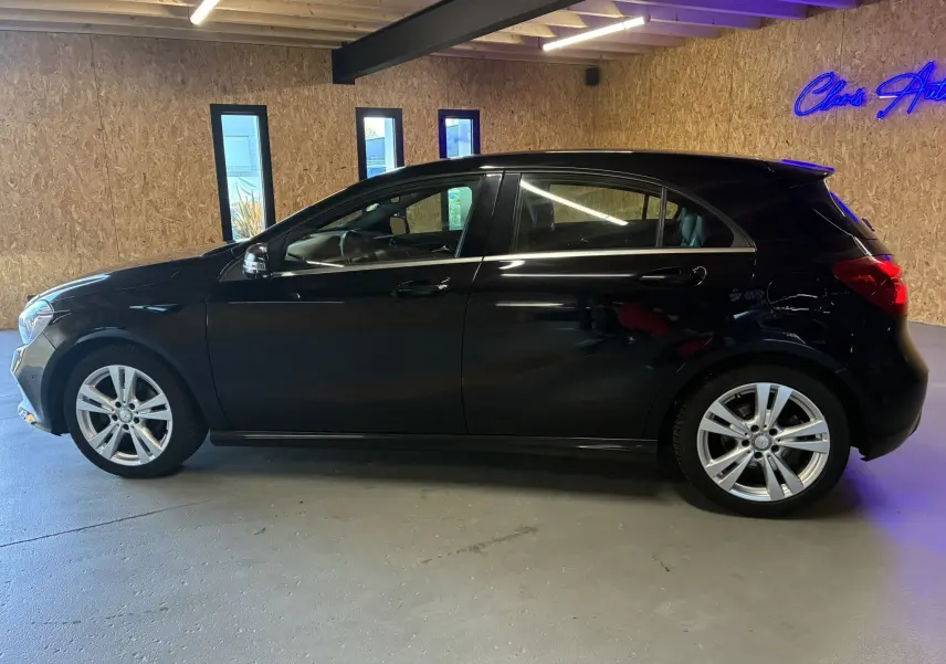 Profil côté gauche d'une Mercedes Classe A 180 CDI Sensation noire, avec jantes alliage et intérieur visible à travers les vitres.