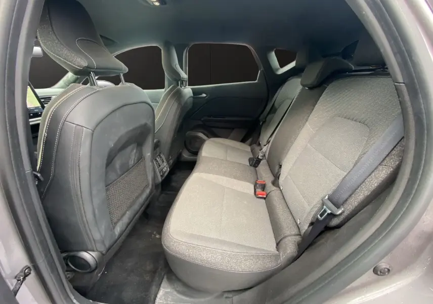 Vue intérieure arrière du Renault Captur 2025, sièges tissu gris et noir avec ceinture de sécurité visible.