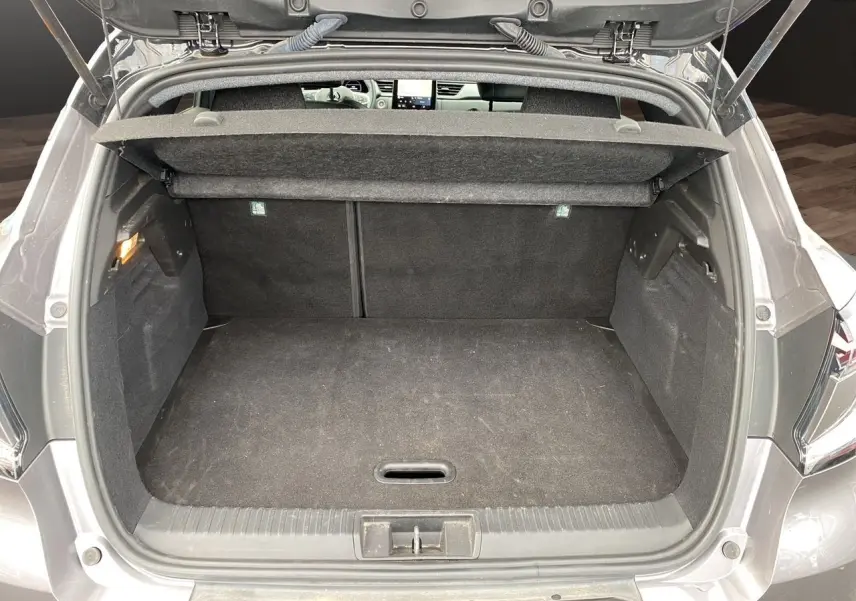 Coffre ouvert vu de l'arrière d'un Renault Captur gris Cassiopée avec intérieur noir et tablette cache-bagages.