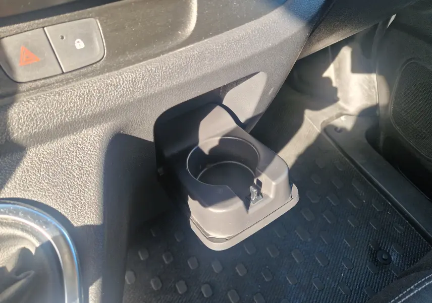 Porte-gobelet en plastique noir déployé côté passager dans l'habitacle du Renault Trafic Fourgon blanc 2021.