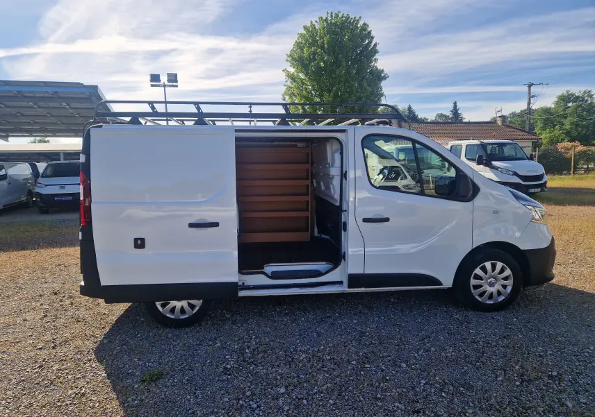 Vue latérale droite d'un Renault Trafic Fourgon blanc 2021 avec porte coulissante ouverte et galerie de toit noire.