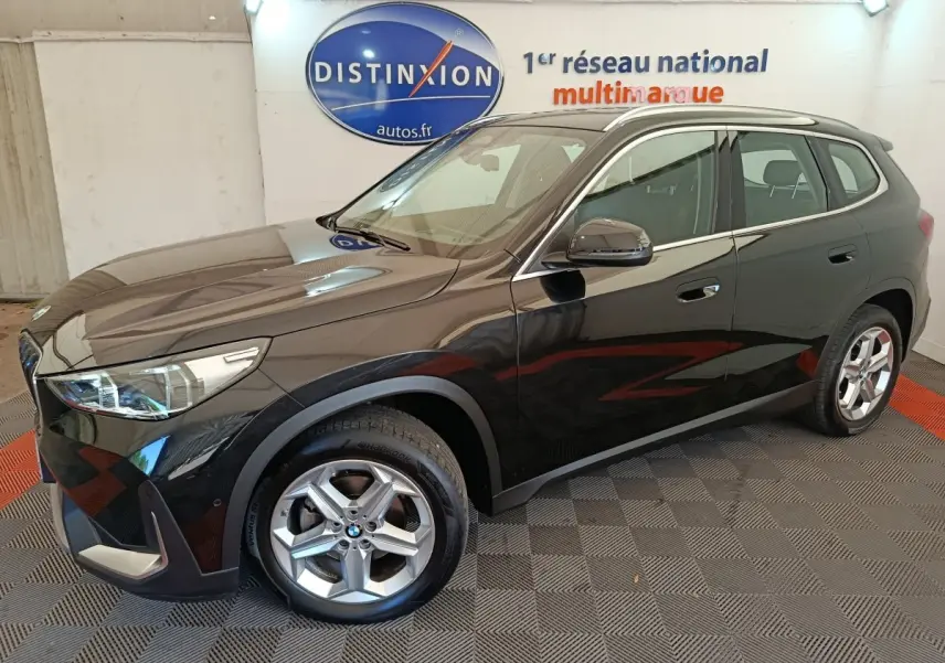 BMW X1 sDrive18i noir en 3/4 avant droit, avec jantes alliage et rétroviseurs rabattables électriquement.