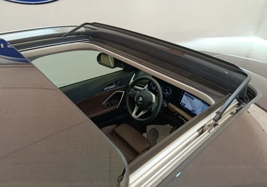 Vue plongeante sur l'intérieur cuir marron et le tableau de bord avec écran tactile du BMW X1 noir 2023.