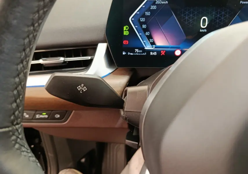 Détail du combiné d'instruments digital et levier de clignotant côté gauche sur BMW X1 sDrive18i 2023 noir.