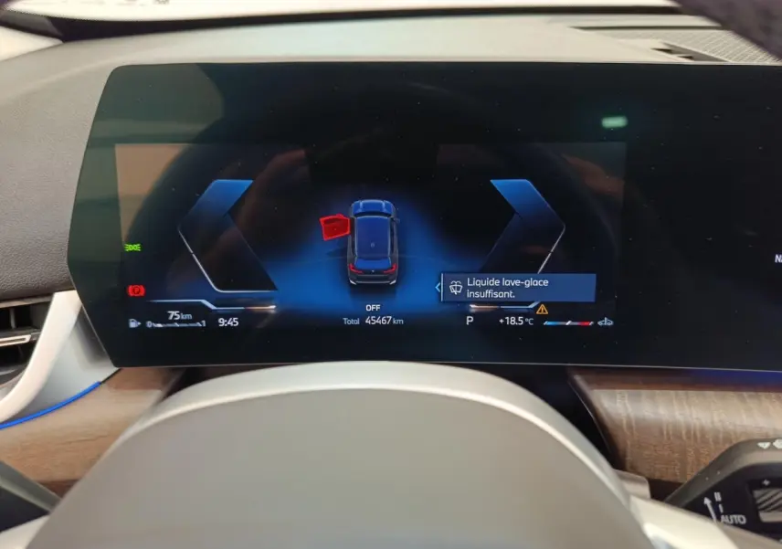 Vue rapprochée du combiné d'instruments numérique du BMW X1 2023, affichant une alerte liquide lave-glace insuffisant.