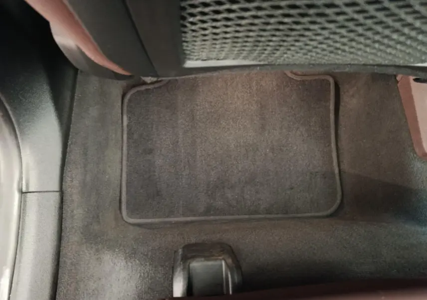 Détail du tapis de sol noir côté passager avant du BMW X1 sDrive18i 2023, intérieur sobre et propre.