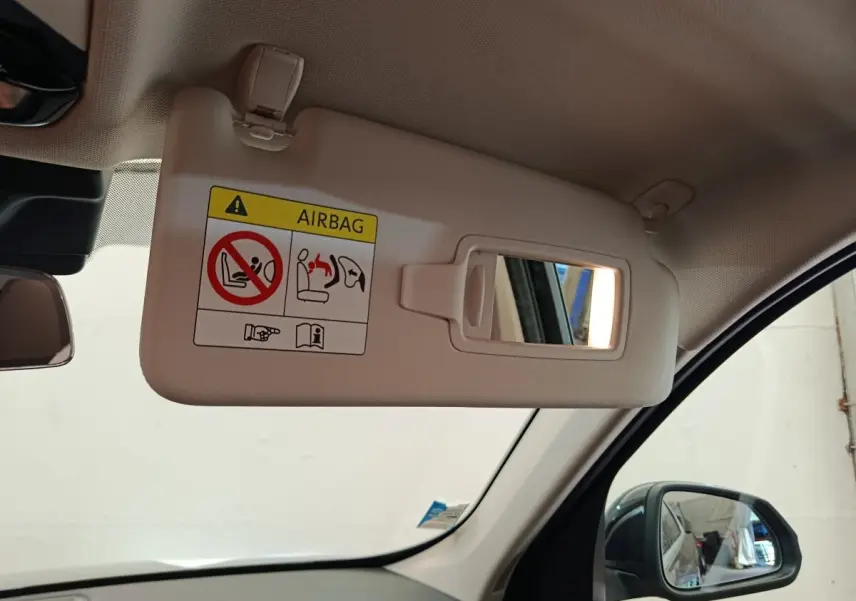 Vue intérieure côté conducteur du pare-soleil beige avec miroir et avertissement airbag sur BMW X1 noir 2023.