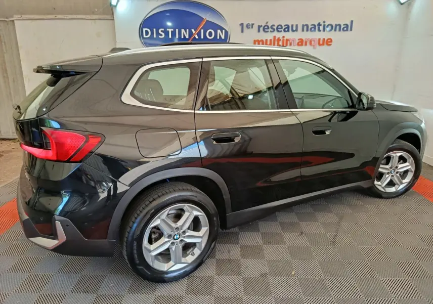 BMW X1 sDrive18i noir vue de profil côté droit, avec jantes alliage et feux arrière LED visibles.