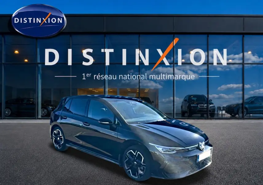 Volkswagen Golf 1.5 eTSI R-Line noire vue 3/4 avant, avec jantes noires et calandre lumineuse LED devant un showroom Distinxion.