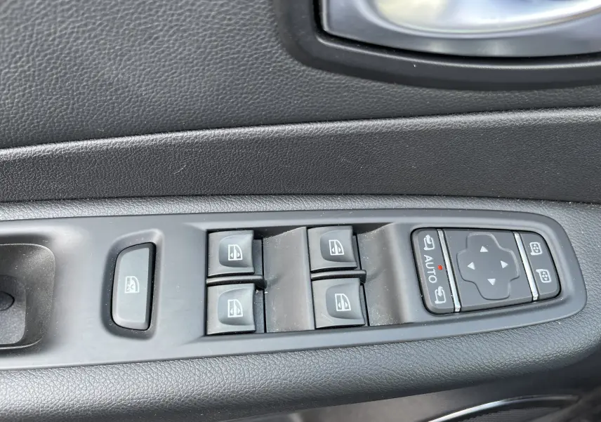 Panneau de commandes des vitres électriques et rétroviseurs sur la portière côté gauche d'un Renault Captur gris 2019.