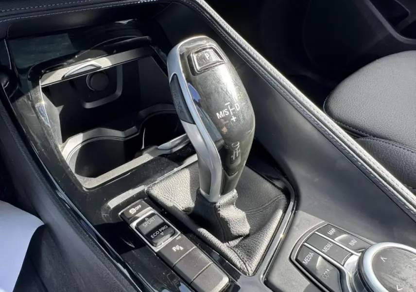 Le levier de vitesses automatique noir et argenté de la BMW X2 M Sport 2021, avec commandes de mode de conduite visibles.