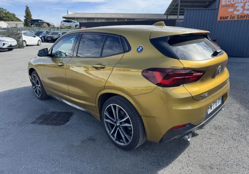 BMW X2 sDrive 18d M Sport jaune métallisé vue 3/4 arrière droit avec jantes alliage 19 pouces et toit ouvrant panoramique