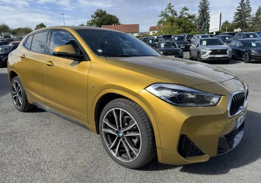 BMW X2 sDrive 18d M Sport jaune métallisé vue 3/4 avant droit avec jantes alliage 19 pouces et toit panoramique.