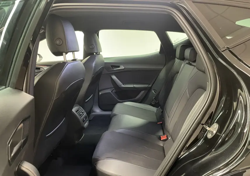 Vue intérieure arrière côté droit du CUPRA Formentor 2025 noir minuit, montrant les sièges et le dossier des sièges avant.