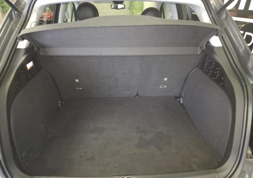 Coffre ouvert vu de l'arrière d'une Fiat 500X 2024 gris, montrant l'espace de chargement et la plage arrière.