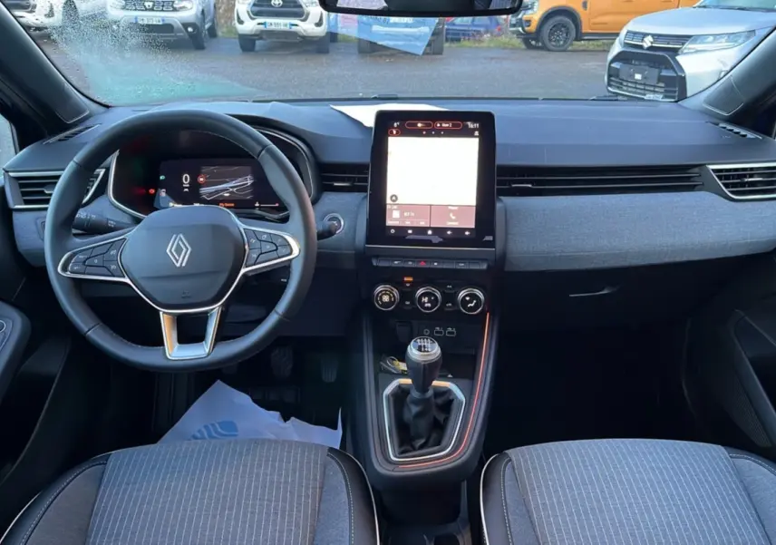 Intérieur de la Renault Clio V TCE 90 Techno Plus 2025, vue avant du tableau de bord avec écran tactile et boîte manuelle.