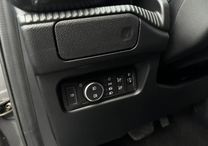 Gros plan sur les commandes d’éclairage noires situées à gauche du volant dans l’habitacle du Ford Ranger 2025.