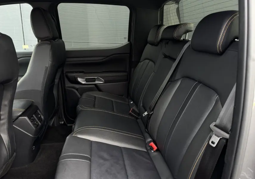 Vue latérale intérieure du siège arrière noir avec surpiqûres contrastantes du Ford Ranger Wildtrak 2025.