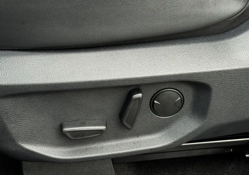 Gros plan sur les commandes de réglage électrique du siège côté conducteur du Ford Ranger 2025, intérieur noir.